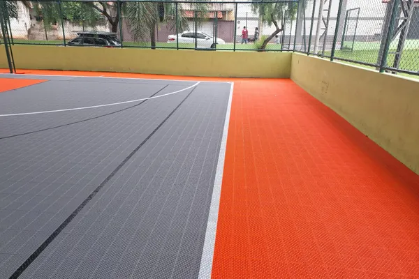 Quadra coberta em piso modular cinza e laranja. Quadra de Esportes Agenor, Extrema, MG.