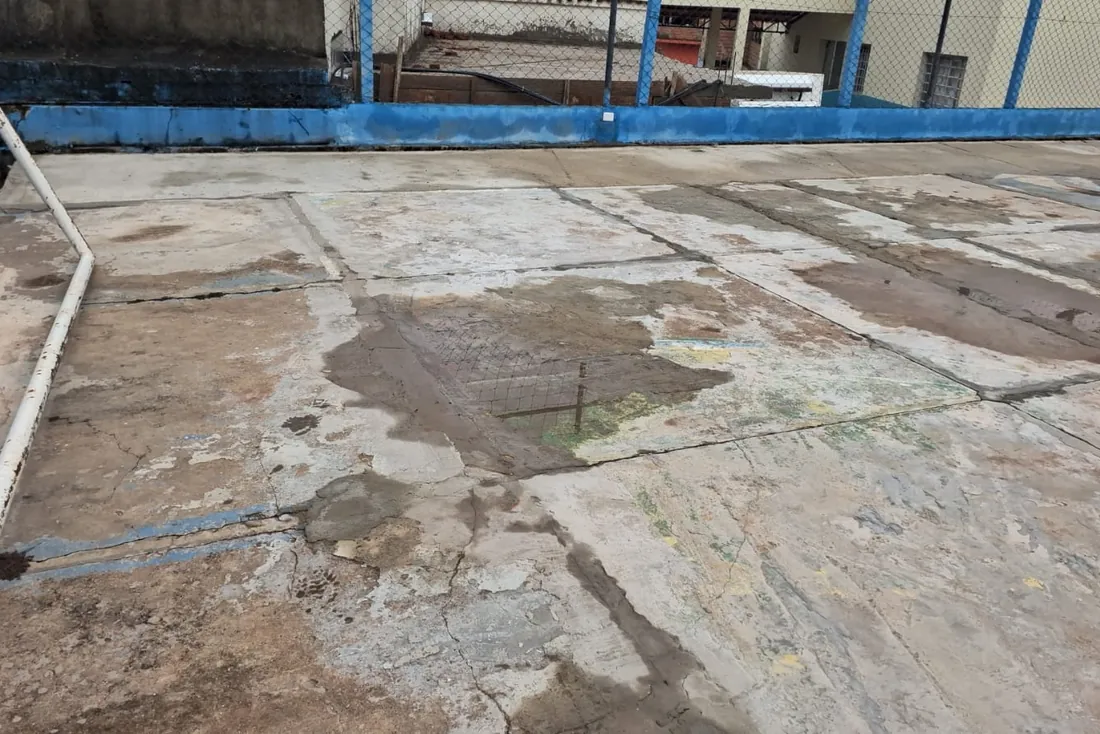 Antes da obra na Praça com playground e quadra: contrapiso trincado e desnivelado em placas