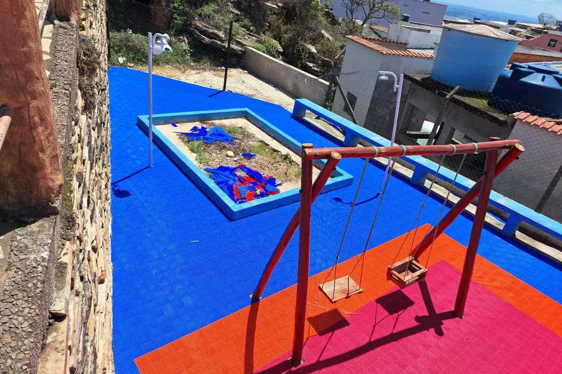 Depois da obra na Praça com playground e quadra: base regularizada e piso de playground instalado sobre ela